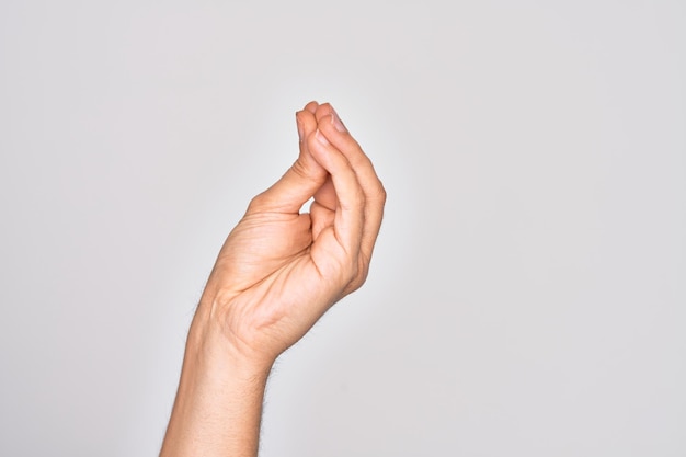 Hand of caucasian young man showing fingers over isolated white background doing Italian gesture with fingers together communication gesture movement