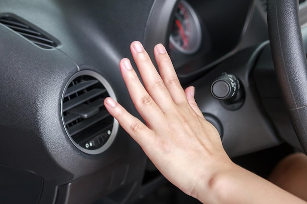 Hand checking air conditioner system inside the car