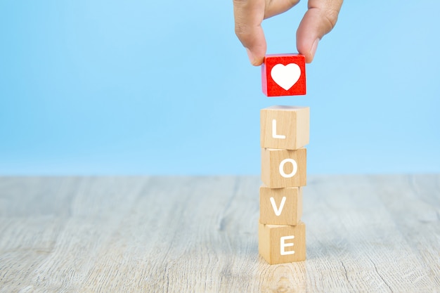 Hand choose a heart-shaped icon with a wooden toy block