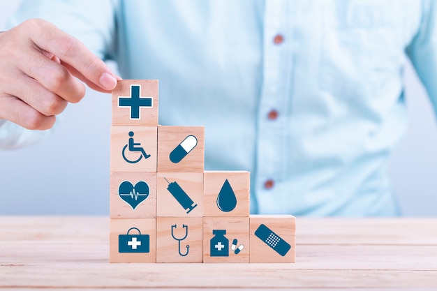 hand chooses a emoticon icons healthcare medical symbol on wooden block , healthcare and medical insurance concept