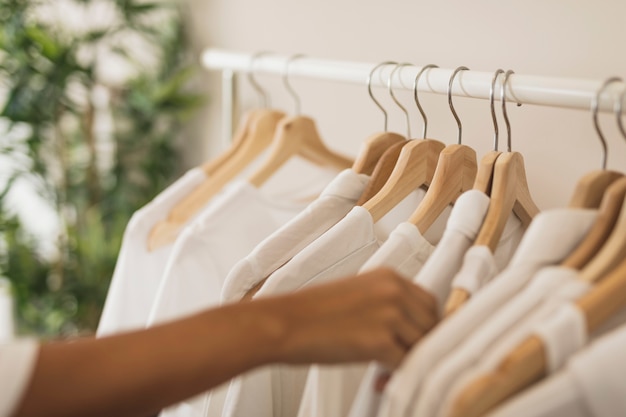 Photo hand choosing a white shirt from wardrobe