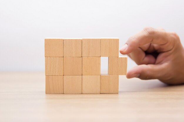 Mano scegliendo blocco di legno senza grafica.