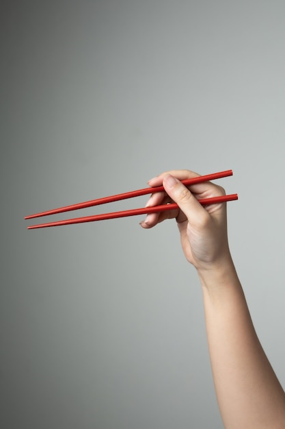 Photo hand chopstick red color asian japanese chinese food style traditional