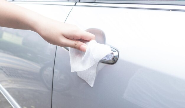 車のドアハンドルを手で洗する 抗菌剤や洗溶液と湿ったタオルを使って