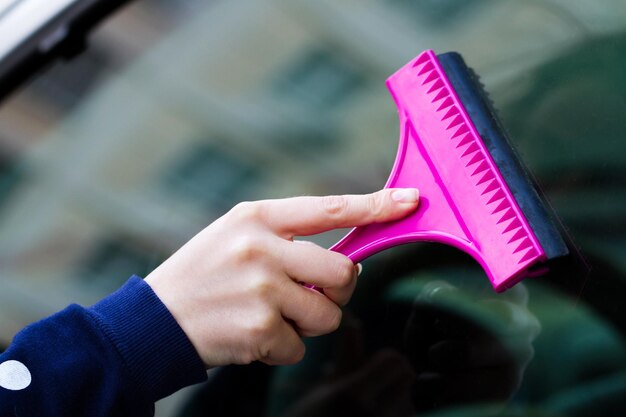 Hand cleaning car glass with a tool