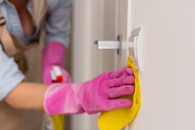 hand cleaning a door with a yellow cloth