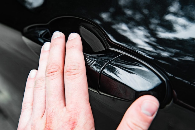 Hand closing car pressing on button of car door. A keyless entry car system.