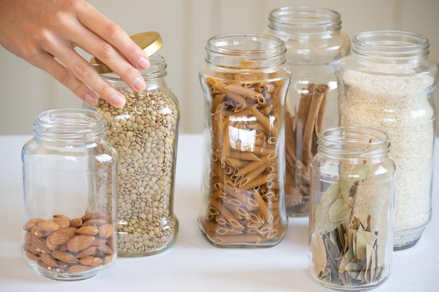 Hand closing glass jars containing food with copy space