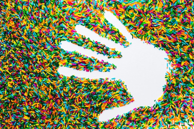 Hand Copyspace on colorful rice on white background