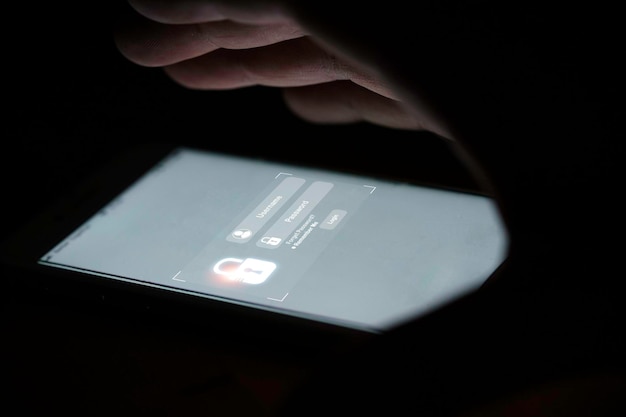 Coprire a mano sul monitor dello smartphone con schermata di nome utente e password per il sistema di sicurezza tecnologica e prevenire il concetto di hacker