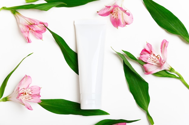 Hand cream blank tube mockup on floral white background.