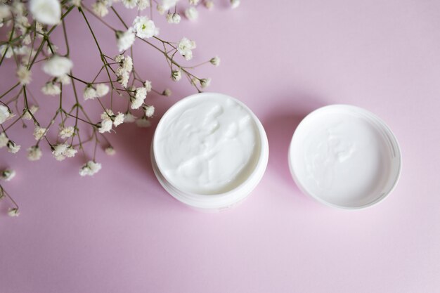 Hand cream in a jar with gopsofila flowers