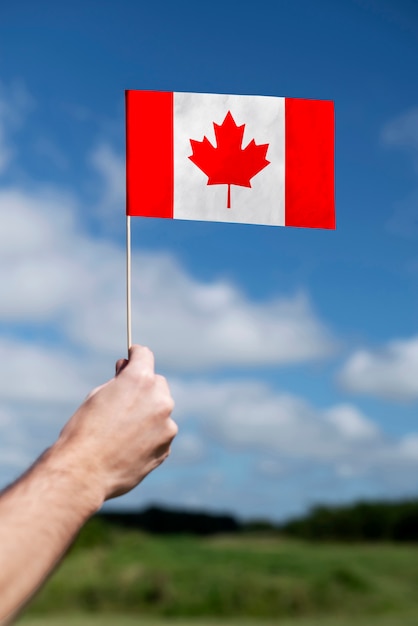 Foto hand die canadese vlag in openlucht houdt