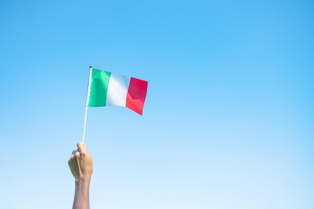 Hand die de vlag van Italië op aardachtergrond houdt Nationale Dag van de Republiek Festa della Repubblica en gelukkige vieringsconcepten