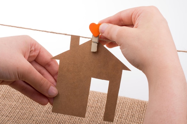 Hand die een papieren huis op doek houdt