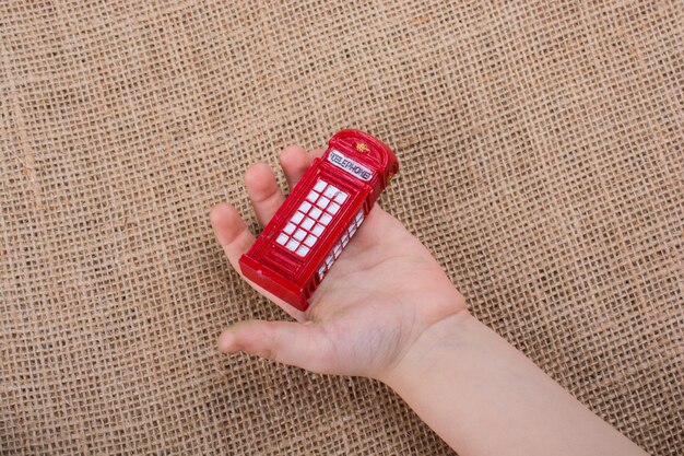 Hand die een rode telefooncel vasthoudt