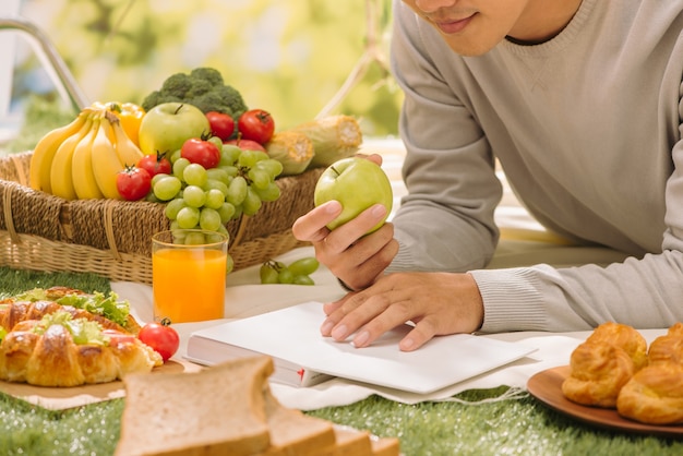 Hand die fruit uit picknickmand in park neemt