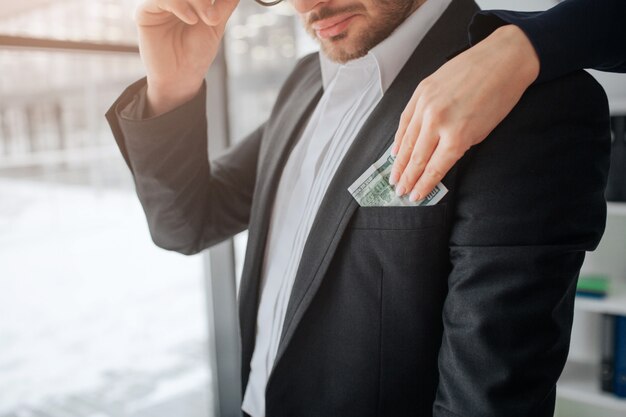 Hand die geld aanbrengt in een zak