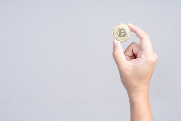 Hand die gouden bitcoin op witte achtergrond houdt
