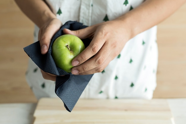 Hand die groene appel schoonmaakt