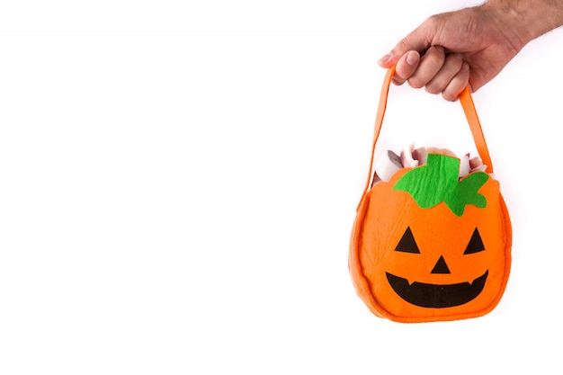 Hand die Halloween-pompoenzak met binnen suikergoed houden