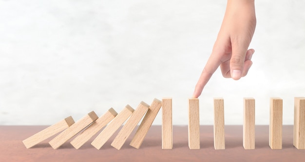 Hand die het Domino-effect stopt, gestopt door uniek