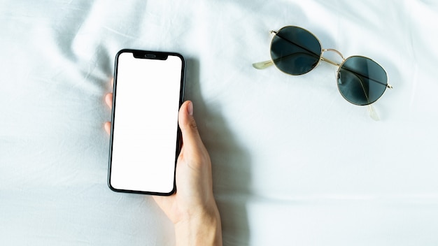 Hand die het lege scherm van smartphone op ruimte gebruiken, tijdens vrije tijd.