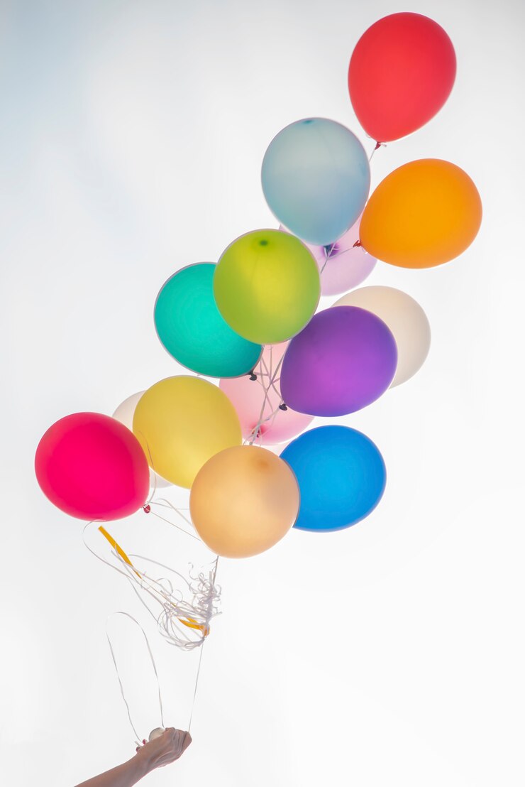 Foto hand die kleurrijke ballonbos op witte achtergrond houdt.