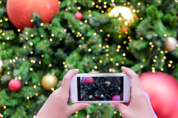 Foto hand die mobiele slimme telefoon met kleurrijke lichte vieringsachtergrond met behulp van