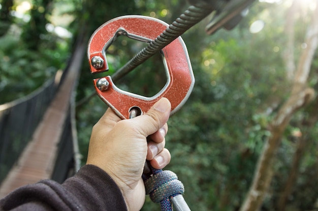 Hand die zipline-materiaal op de het lopen boom, avontuur houdt