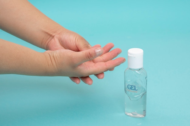 Hand disinfection with antibacterial gel on a blue background