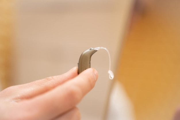 Hand of a doctor holding a hearing aid