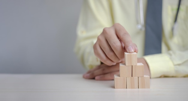 Hand doctor holding wood cube blockBusiness growth success concept panorama background