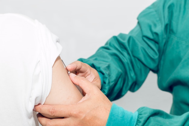 Hand of doctor inject vaccine to patient.