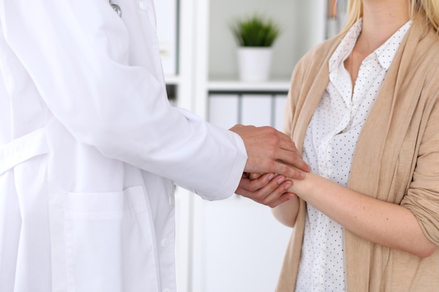 Hand of doctor  reassuring her female patient. Medical ethics and trust concept