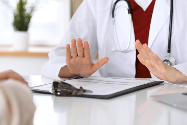 Hand of doctor  reassuring her female patient. Medical ethics and trust concept