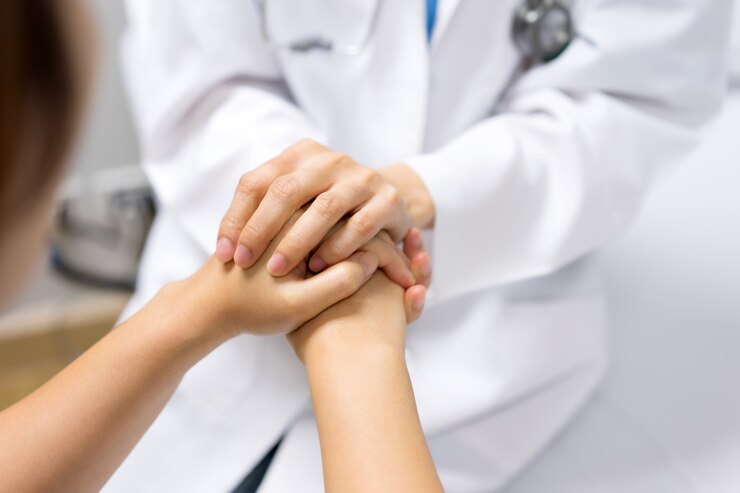 Photo hand of doctor reassuring her female patient