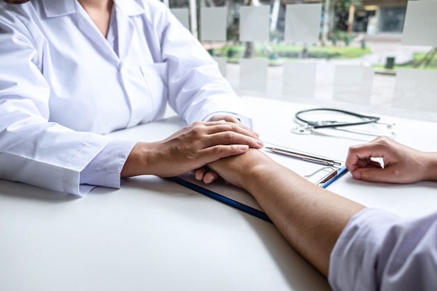 Hand of doctor touching patient reassuring for encouragement and empathy to support while medical examination on the hospital.