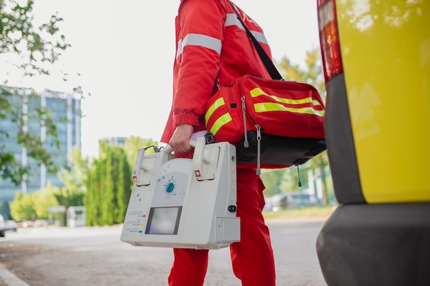 Foto la mano del medico con il defibrillatore le squadre del servizio medico di emergenza stanno rispondendo ad un incidente stradale