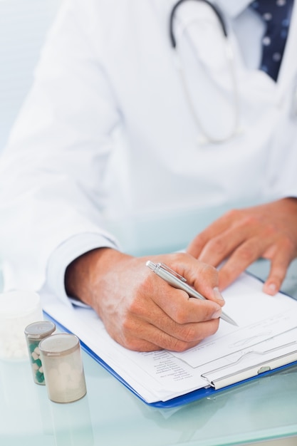 Hand of a doctor writing on a prescription pad