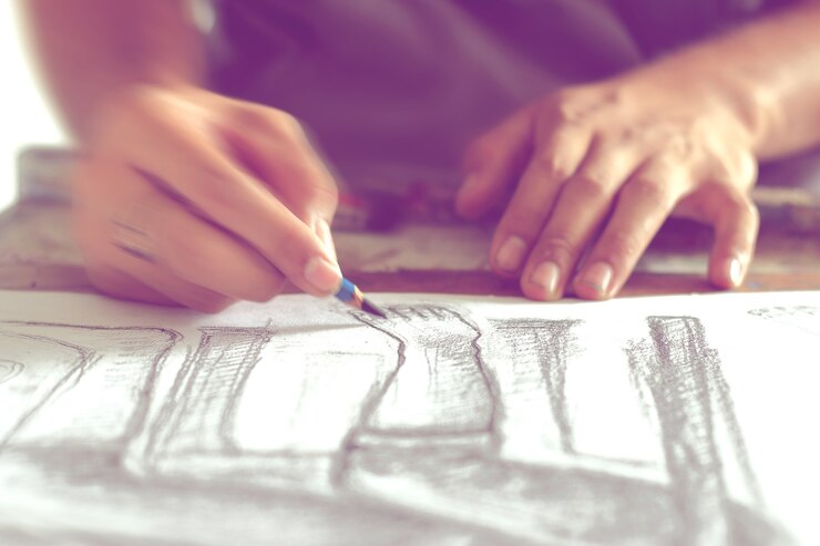 Photo hand drawing the human figure with a pencil, blurred movement.
