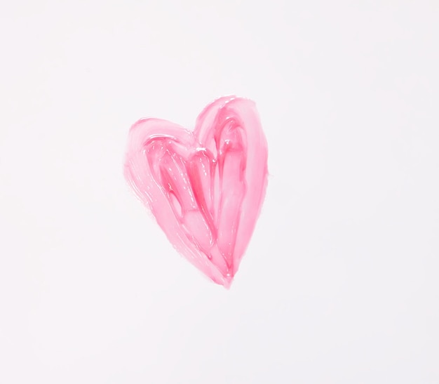 Ручная рисованная форма сердца. Образец розового блеска для губ на белом фоне.