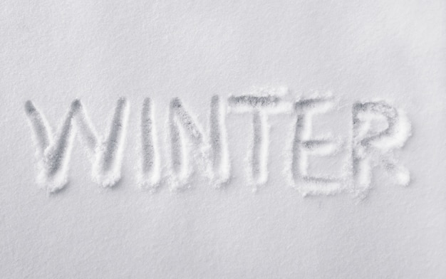 Parola di inverno disegnato a mano su neve bianca fresca