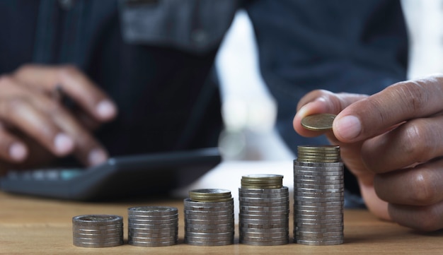 Hand drop a coin with money coin stack growing for business