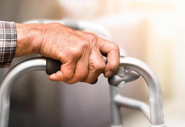 Hand of an elderly person and a walker