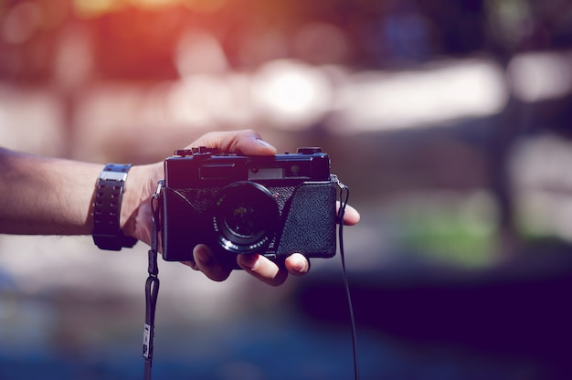 Hand en camera van de fotograaf Reis in de bergen en de natuur Conceptfotograaf