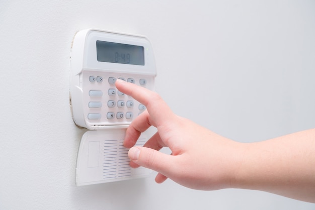 Hand entering alarm system password.