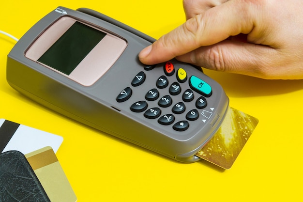 Hand entering pin code to money terminal before payment