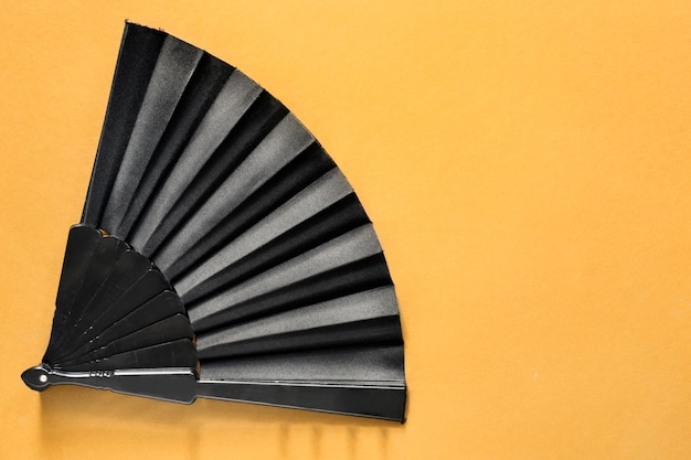 Hand fan on yellow background