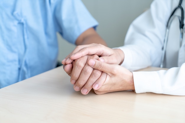 Hand of female doctor holding on her senior patient